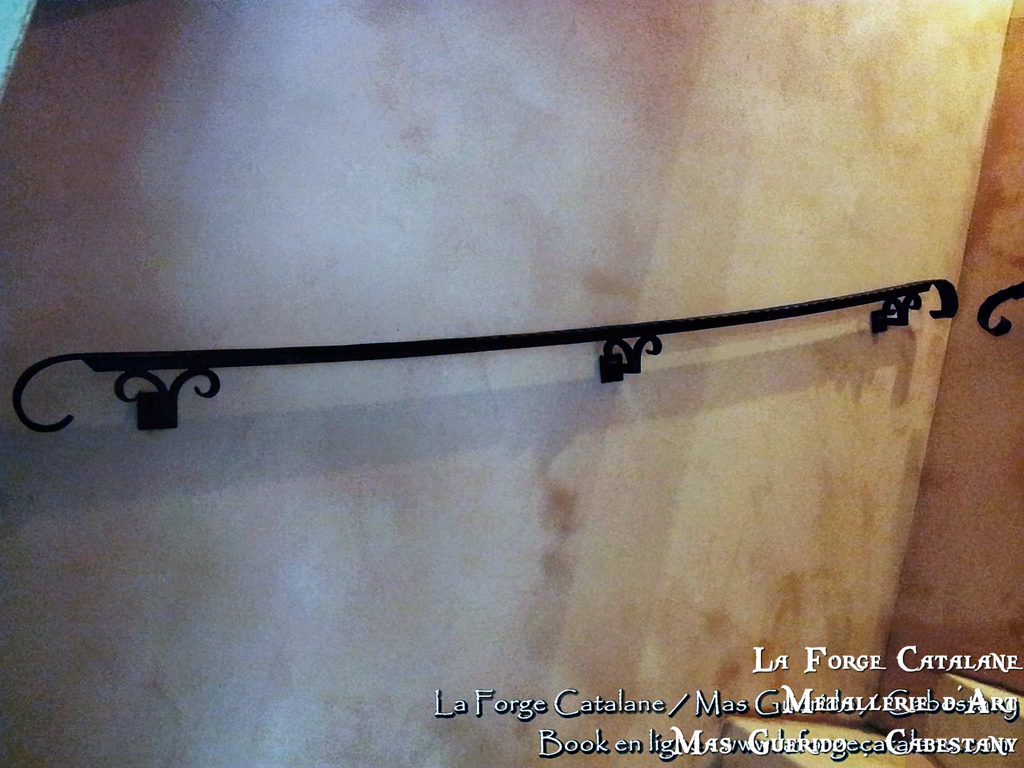 main courante martele avec cavalier de fixations en forme de volutes et crosses de finition arrondi  forge catalane.jpg